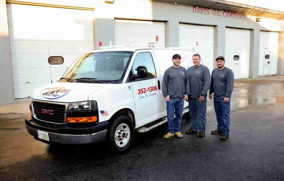 Three Davis Oil employees standing in front of one of their service vans